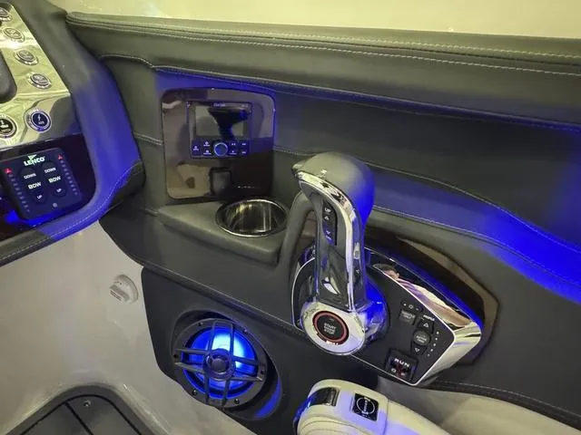 Slide: The Image of 2024 Chaparral 307 SSX boat interior with control panel, throttle, and blue LED lighting. - 13