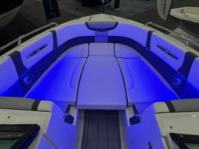 Slide: The Image of 2024 Chaparral 307 SSX boat interior with blue LED lighting and cushioned seating. - 18