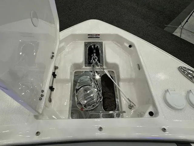 Slide: The Image of 2024 Chaparral 307 SSX boat anchor compartment with open hatch and visible anchor chain. - 19