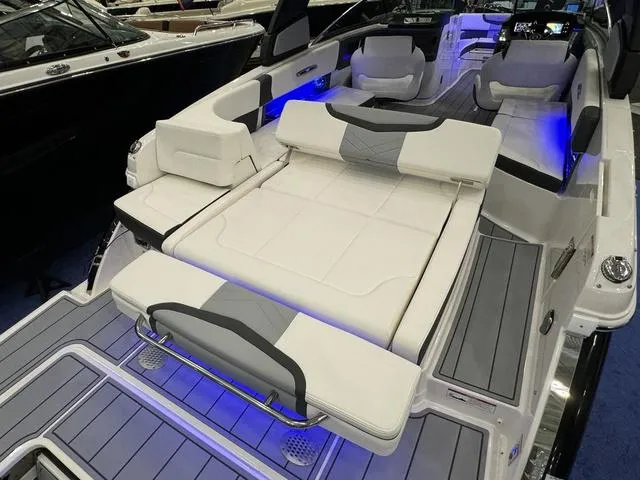 Slide: The Image of 2024 Chaparral 307 SSX boat interior with luxurious seating and ambient blue lighting. - 6