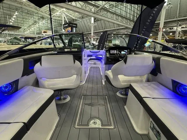 Slide: The Image of 2024 Chaparral 307 SSX boat interior with modern seating and blue LED lighting. - 7