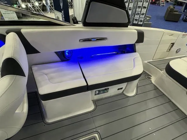 Slide: The Image of 2024 Chaparral 307 SSX boat interior with blue LED lighting and white seating. - 9