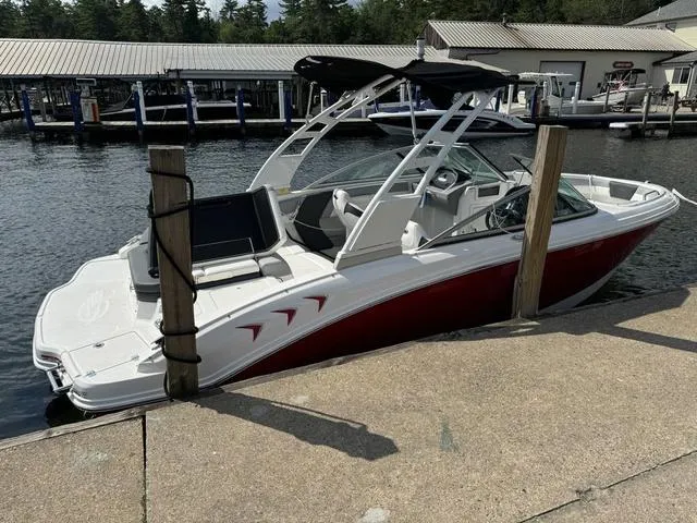 Slide: The Image of 2024 Chaparral 21 SSi boat docked, featuring sleek red and white design. - 11