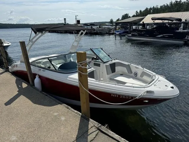 Slide: The Image of 2024 Chaparral 21 SSi boat docked at a marina on a sunny day. - 2