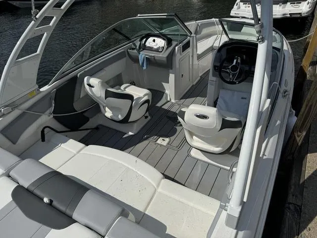 Slide: The Image of 2024 Chaparral 21 SSi boat interior with seating and steering wheel, docked by the water. - 4