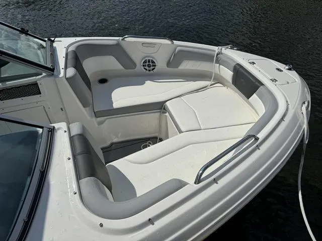 Slide: The Image of 2024 Chaparral 21 SSi boat with spacious seating, docked on calm water. - 5