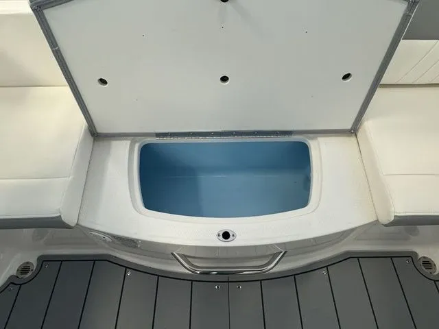 Slide: The Image of 2024 Chaparral 21 SSi boat storage compartment with open lid, showcasing interior space. - 13