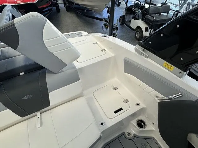 Slide: The Image of 2024 Chaparral 21 SSi boat interior with white and gray seating, storage compartments. - 14