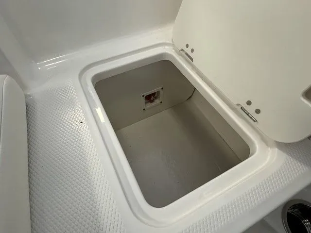 Slide: The Image of 2024 Chaparral 21 SSi boat storage compartment with open lid, showcasing interior space. - 15