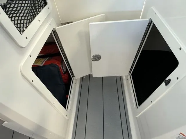 Slide: The Image of 2024 Chaparral 21 SSi boat storage compartments with open doors, showcasing interior space. - 18