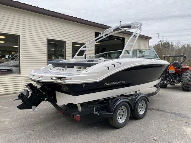 Slide: The Image of 2024 Chaparral 21 SSi boat on trailer, parked outside a building. - 6