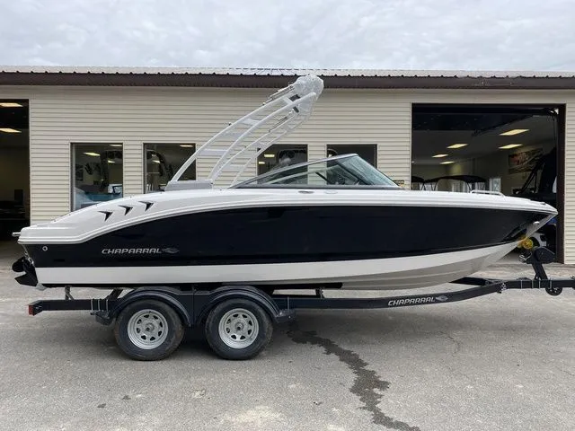 Slide: The Image of 2024 Chaparral 21 SSi boat on trailer, sleek design, parked outside a building. - 7