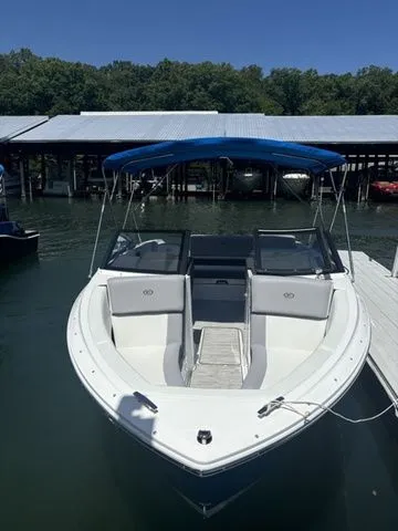 Slide: The Image of 2024 Cobalt CS22 boat docked with blue canopy, white interior, and sleek design. - 2