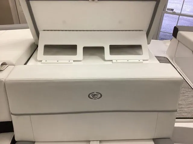 Slide: The Image of 2024 Cobalt 220S boat interior with white cushioned seating and storage compartment. - 17