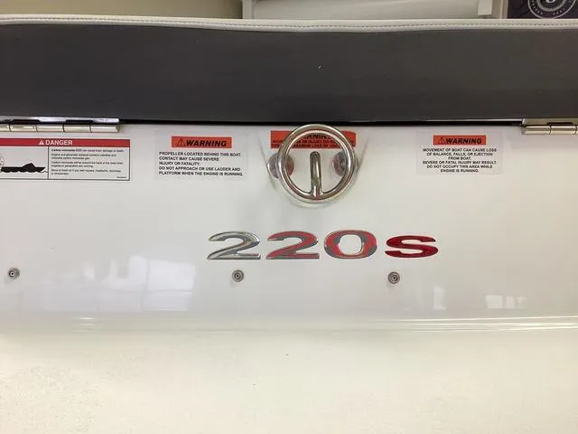 Slide: The Image of 2024 Cobalt 220S boat stern with warning labels and logo. - 3