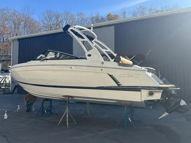 Slide: The Image of 2025 Cobalt R4 Surf boat on stands, outdoor setting, clear sky. - 1