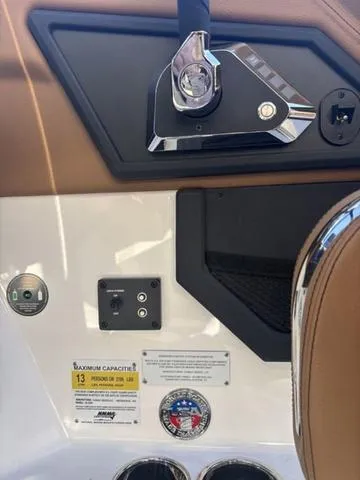 Slide: The Image of 2025 Cobalt R4 Surf boat interior with control panel and capacity label. - 11