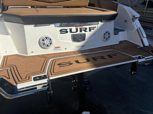 Slide: The Image of 2025 Cobalt R4 Surf boat rear deck with speakers and cushioned seating. - 5