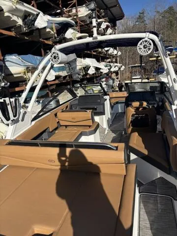 Slide: The Image of 2025 Cobalt R4 Surf boat with tan seating and modern design in storage facility. - 6