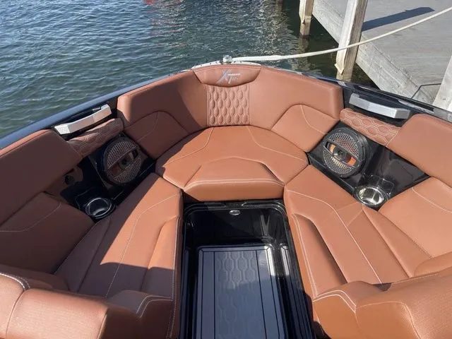 Slide: The Image of Luxurious seating in 2024 MasterCraft XT22 T boat, featuring premium brown upholstery and integrated speakers. - 10