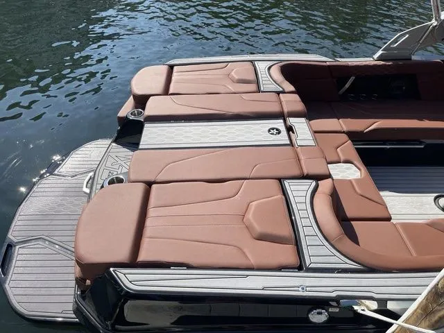 Slide: The Image of 2024 MasterCraft XT22 T boat with luxurious brown seating on the water. - 4