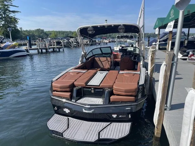 Slide: The Image of 2024 MasterCraft XT22 T boat docked, featuring luxurious seating and sleek design. - 6