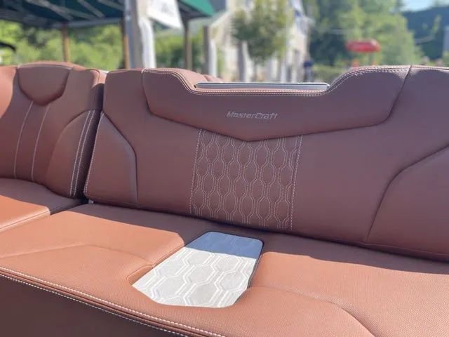 Slide: The Image of 2024 MasterCraft XT22 T boat interior with brown leather seating and stylish stitching. - 8