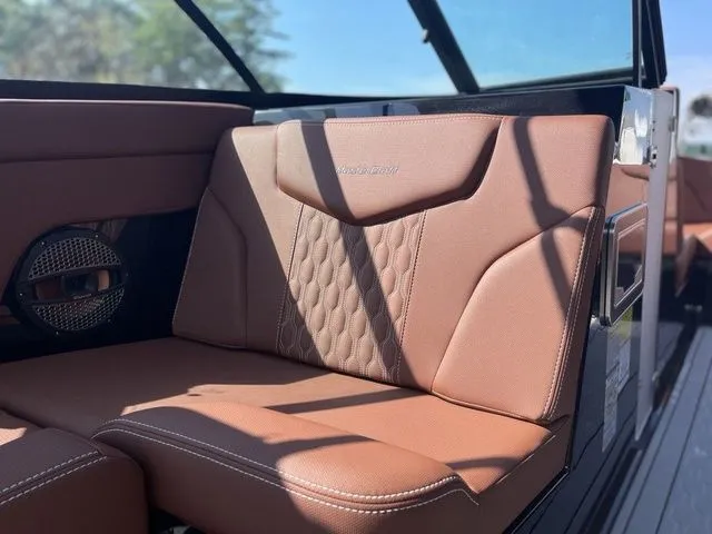 Slide: The Image of 2024 MasterCraft XT22 T boat interior with brown leather seating and speaker detail. - 9