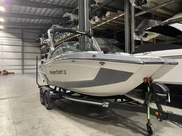 Slide: The Image of 2024 MasterCraft XT20 boat in a warehouse, on a trailer, ready for transport. - 1