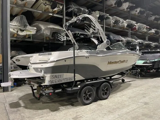 Slide: The Image of 2024 MasterCraft XT20 boat on trailer in storage facility. - 2