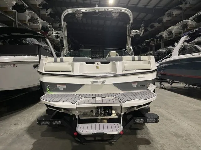 Slide: The Image of 2024 MasterCraft XT20 boat in a showroom, rear view showcasing swim platform and seating. - 3