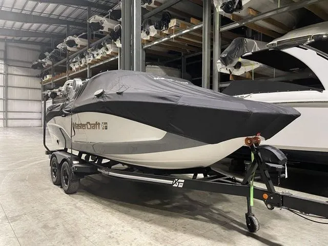 Slide: The Image of 2024 MasterCraft XT20 boat covered in storage, on a trailer in a warehouse. - 6