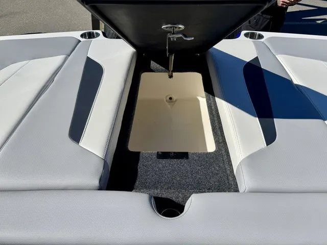 Slide: The Image of 2022 MasterCraft XStar boat interior storage compartment with open lid, showcasing sleek design. - 12