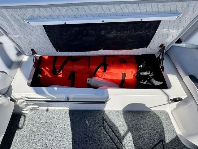 Slide: The Image of 2022 MasterCraft XStar storage compartment with life jackets and safety equipment. - 19