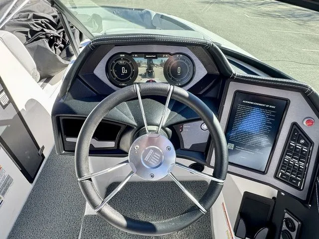 Slide: The Image of 2022 MasterCraft XStar boat dashboard with steering wheel and digital displays. - 23