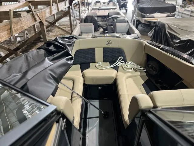Slide: The Image of 2024 MasterCraft X24 boat interior with beige seating and black accents. - 13