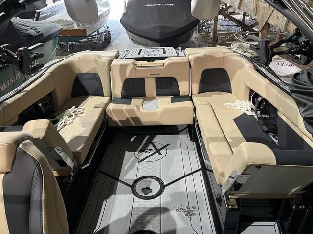 Slide: The Image of 2024 MasterCraft X24 boat interior with beige seating and sleek design. - 7