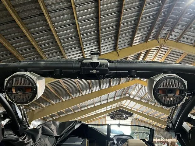 Slide: The Image of 2024 MasterCraft X24 boat with speakers under a metal roof in a storage facility. - 8