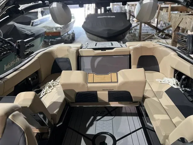 Slide: The Image of 2024 MasterCraft X24 boat interior with beige seating and modern design. - 9