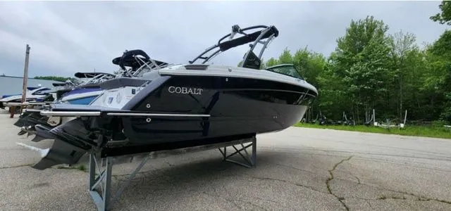 Slide: The Image of 2024 Cobalt R8 boat on display, sleek design, black exterior, parked outdoors. - 2