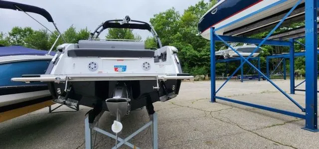 Slide: The Image of 2024 Cobalt R8 boat on display, surrounded by trees and other boats. - 3