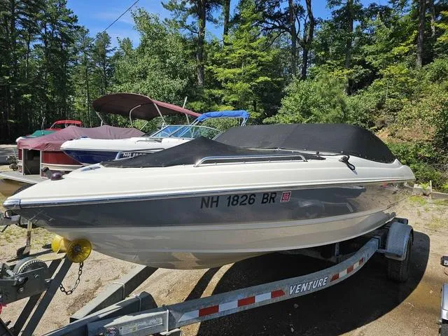 Slide: The Image of 2011 Stingray 195 LX boat on trailer, covered, surrounded by trees and other boats. - 3