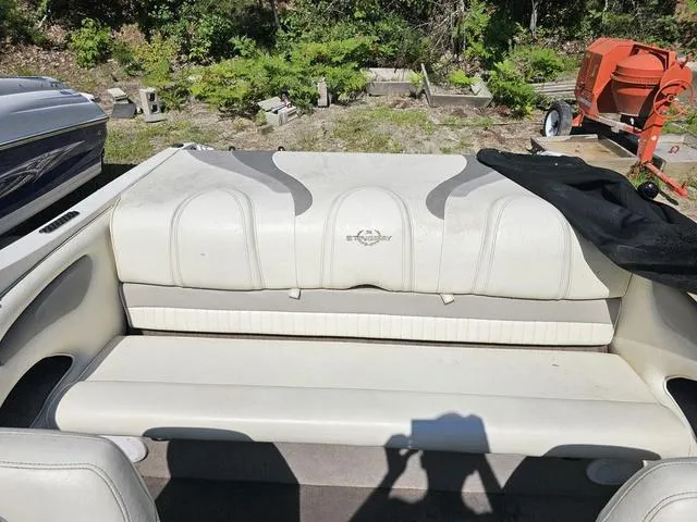 Slide: The Image of 2011 Stingray 195 LX boat interior with white seating and logo, outdoors. - 4