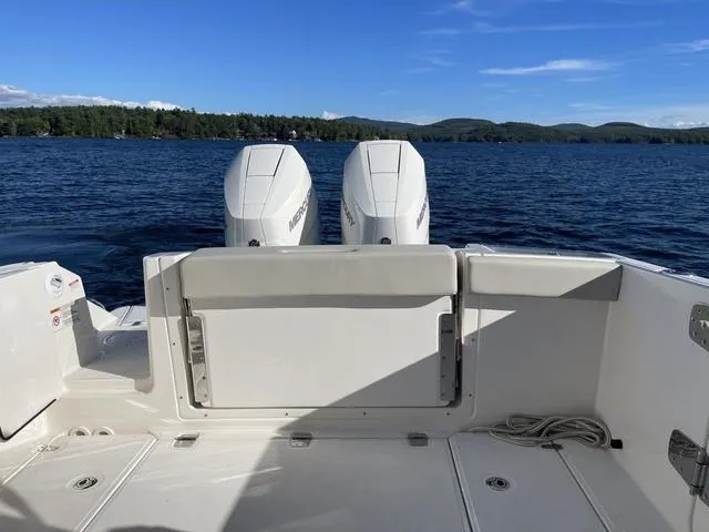 Slide: The Image of 2024 Boston Whaler 280 Vantage boat with dual engines on a serene lake. - 14