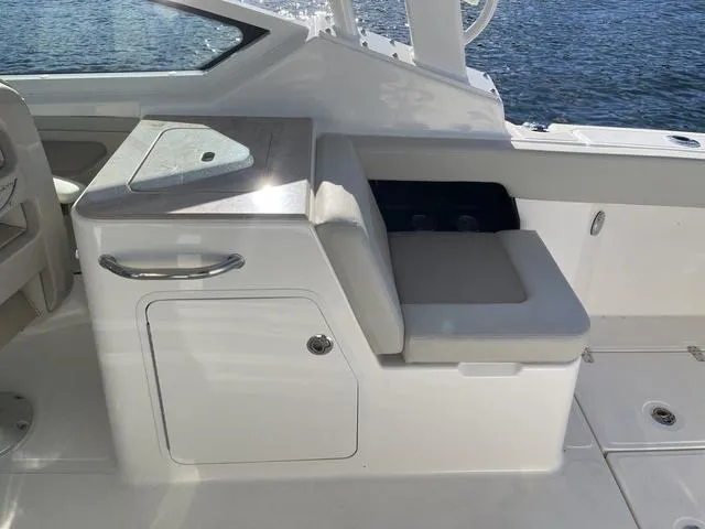 Slide: The Image of 2024 Boston Whaler 280 Vantage interior seating and storage area by the water. - 21