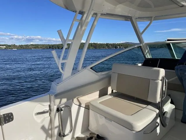 Slide: The Image of 2024 Boston Whaler 280 Vantage boat interior with seating, on a scenic lake. - 28