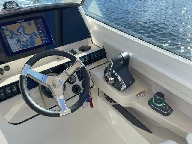 Slide: The Image of 2024 Boston Whaler 280 Vantage helm with steering wheel, controls, and navigation display. - 29