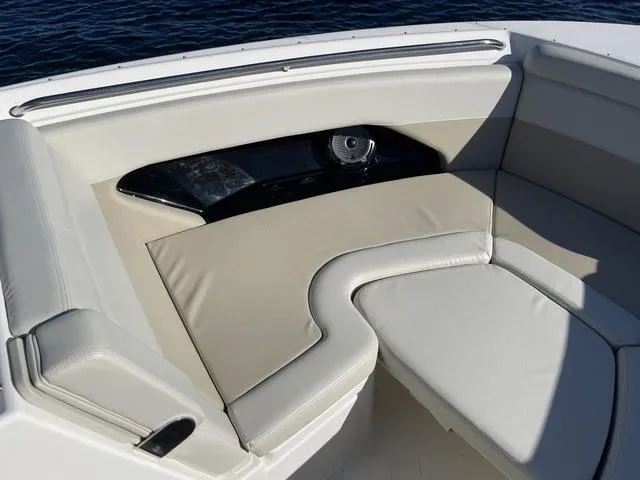 Slide: The Image of 2024 Boston Whaler 280 Vantage boat interior with cushioned seating and speaker. - 34