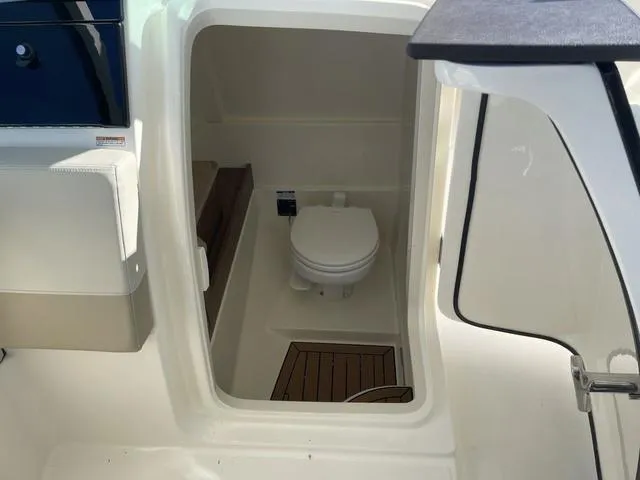 Slide: The Image of 2024 Boston Whaler 280 Vantage boat interior with compact marine toilet. - 36