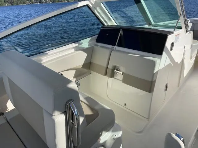 Slide: The Image of 2024 Boston Whaler 280 Vantage interior with seating, windshield, and lake view. - 37